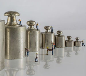 Close-up of weights with figurines on white background