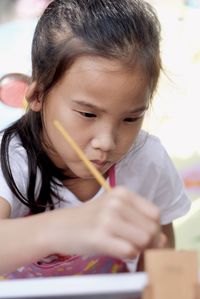 Close-up of cute girl holding paintbrush 