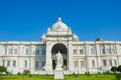 Statue of historic building against blue sky