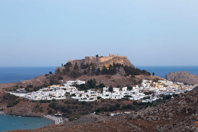 Scenic view of sea by buildings against clear sky