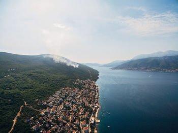 High angle view of city by sea against sky