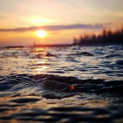 Close-up of sea against sky during sunset