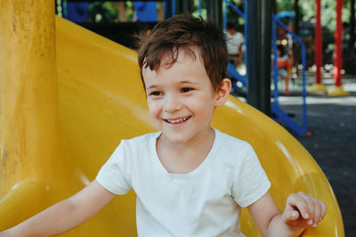 Portrait of cute boy sitting on swing