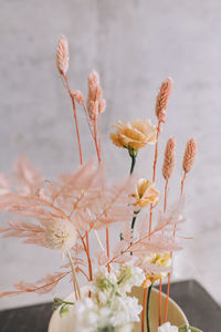 Close-up of dried flowers centerpiece with a concrete wall on the back 