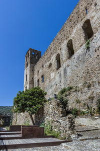 Low angle view of castle against clear blue sky