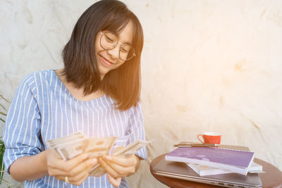 Young woman reading book on table