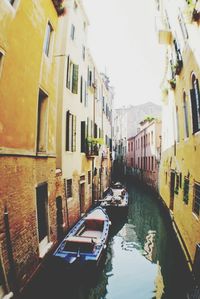 Boats in canal along buildings