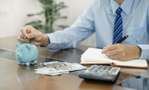 Midsection of businessman working on table
