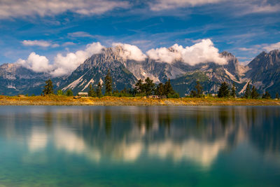 Scenic view of lake by mountains against sky