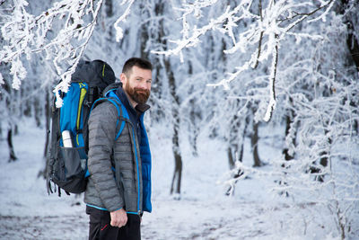 Portrait of young man standing in snow