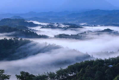 Scenic view of trees and mountains against sky