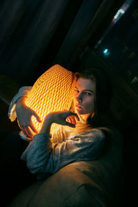 Portrait of teenage girl with lamp at night