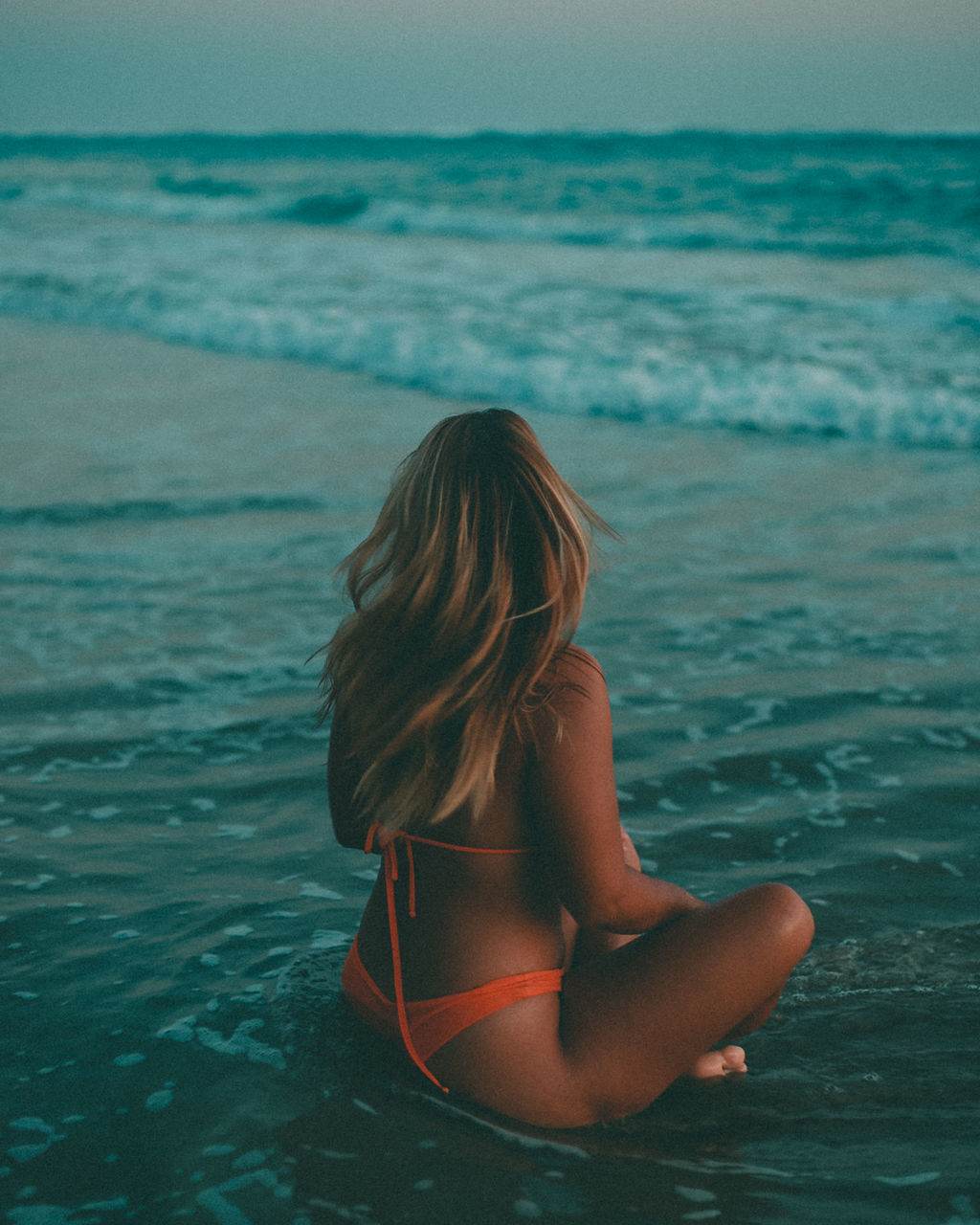 water, sea, one person, ocean, women, wave, clothing, land, rear view, nature, long hair, adult, hairstyle, holiday, relaxation, vacation, trip, swimming, beauty in nature, leisure activity, beach, swimwear, lifestyles, young adult, bikini, horizon, horizon over water, summer, sky, tranquility, shore, blond hair, sunlight, sitting, female, wind wave, outdoors, blue, tranquil scene, solitude, day, person, idyllic, motion, scenics - nature, child, back, body of water, sports, childhood, coast, three quarter length, fashion