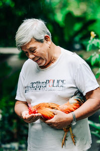 Man feeding rooster