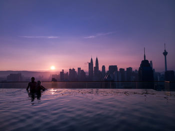 Silhouette of buildings against sky during sunset