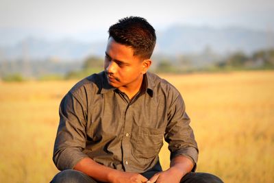 Full length of young man sitting on field