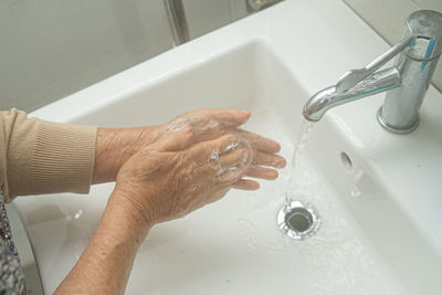 High angle view of hands in bathroom