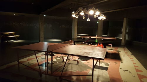 Empty chairs and table in illuminated room