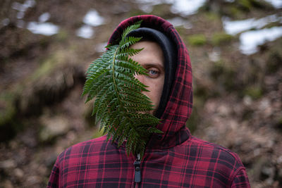 Portrait of young man with leaf during winter