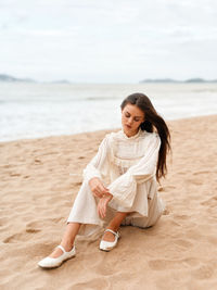 Portrait of young woman sitting at beach