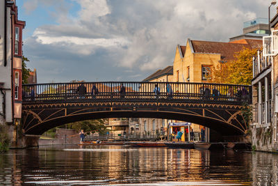 Bridge over river in city of cambridge in england with punting boats on a golden evening sun