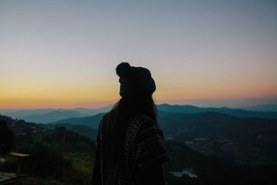 Silhouette man looking at mountain against sky during sunset