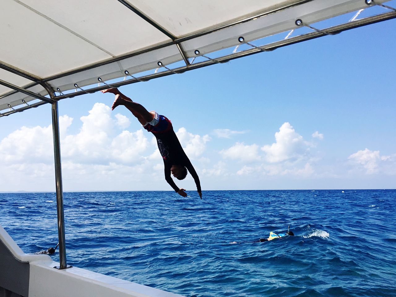 water, full length, lifestyles, leisure activity, sea, sky, jumping, mid-air, enjoyment, horizon over water, fun, men, cloud - sky, sport, standing, casual clothing, vacations, balance