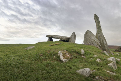 Stone wall on field against sky