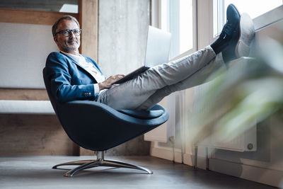 Portrait of man sitting on sofa at home