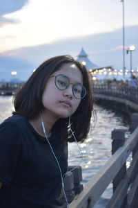 Portrait of beautiful young woman standing against sky