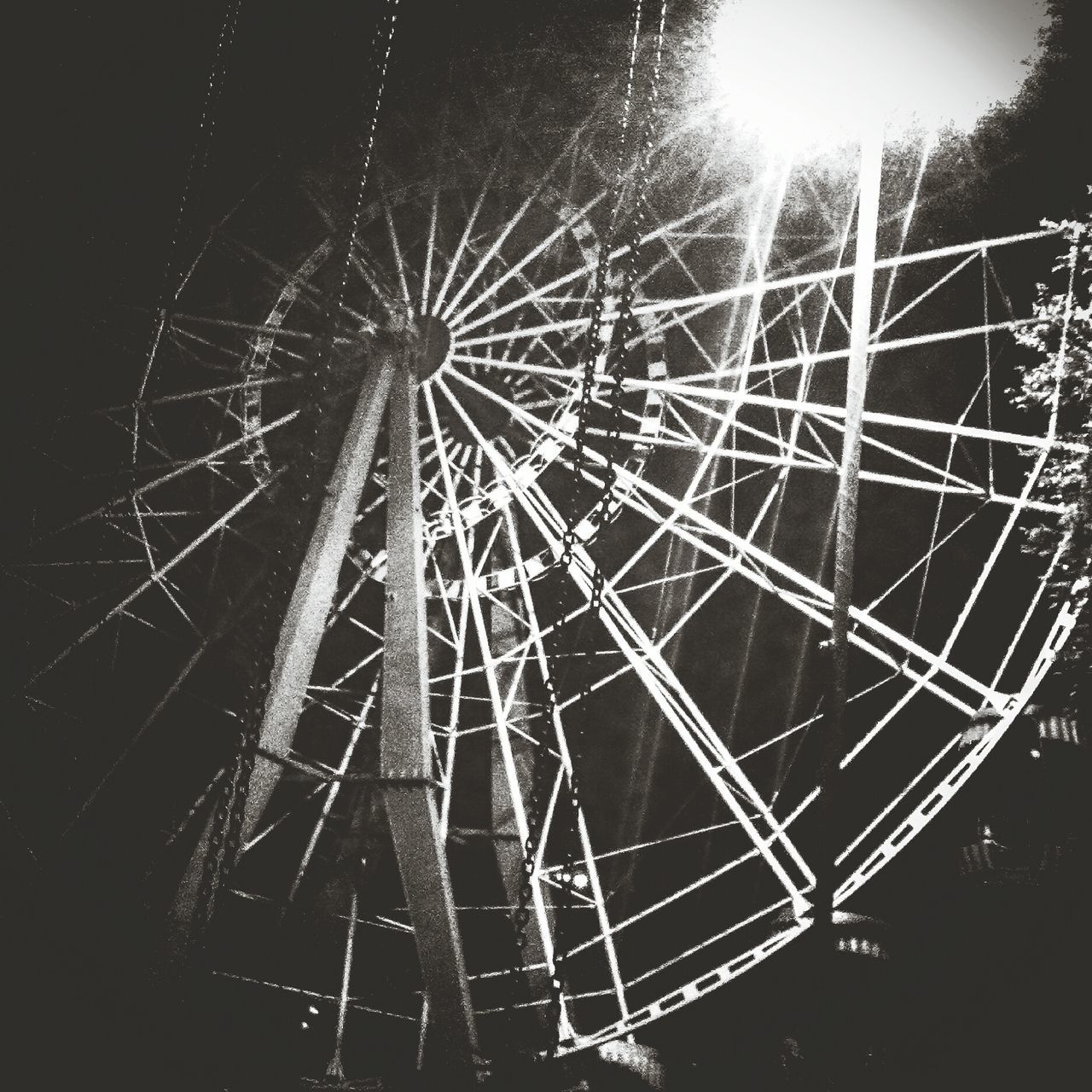 arts culture and entertainment, ferris wheel, amusement park, low angle view, amusement park ride, sky, night, clear sky, tree, outdoors, no people, large, motion, built structure, leisure activity, environmental conservation, windmill, enjoyment, fun, silhouette