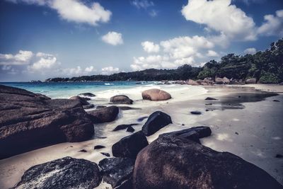 Rocks at beach against sky