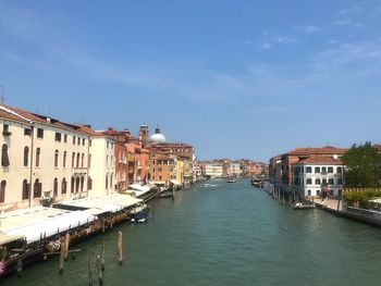 Canal amidst buildings in city against sky