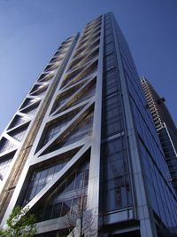 Low angle view of modern building against blue sky