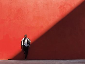 Man standing on red umbrella