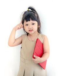 Portrait of cute girl standing against white background