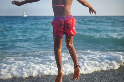 Low section of people standing on beach