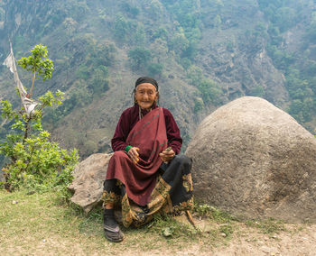 Full length of young man sitting on mountain