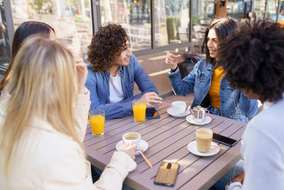 Happy friends talking at cafe