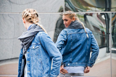 Woman standing against mirror