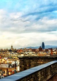 Buildings in city against cloudy sky