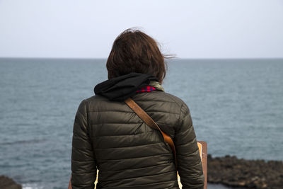 Rear view of woman looking at sea against sky