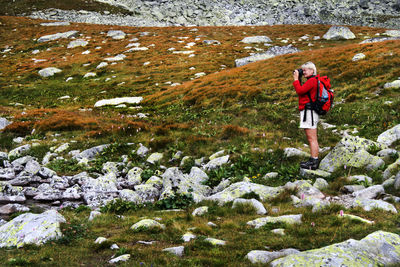 Full length of man with arms raised on mountain