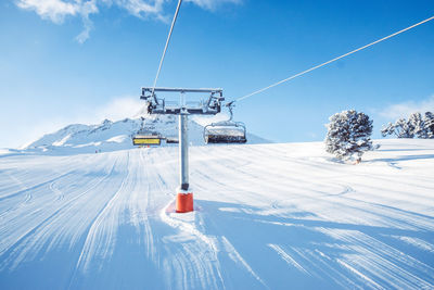 Ski lift over snowcapped mountain against sky