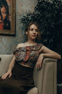 Young woman sitting on sofa at home