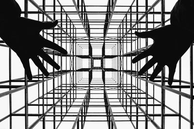 Low angle view of silhouette people on metal structure