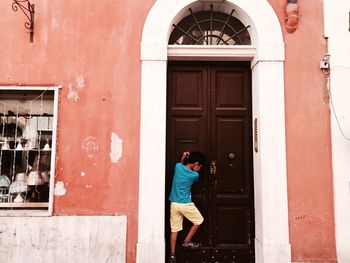 Woman standing by door of building