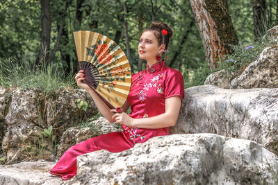 Portrait of woman sitting on rock