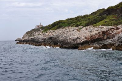 Scenic view of rocks on beach against sky