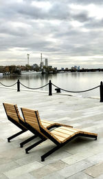 Pier on lake against sky in city